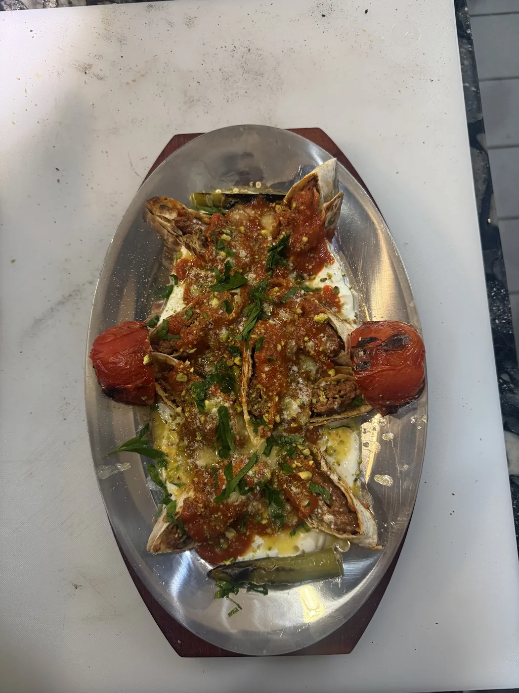 Fıstıklı sarma beyti — adana kebab rolled in lavash with yoghurt, pistachio and tomato sauce