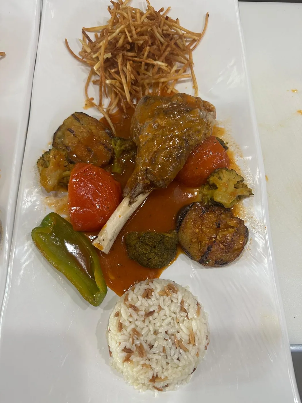 İslim kebabı — lamb shank with rice, tomato, pepper and broccoli in sauce